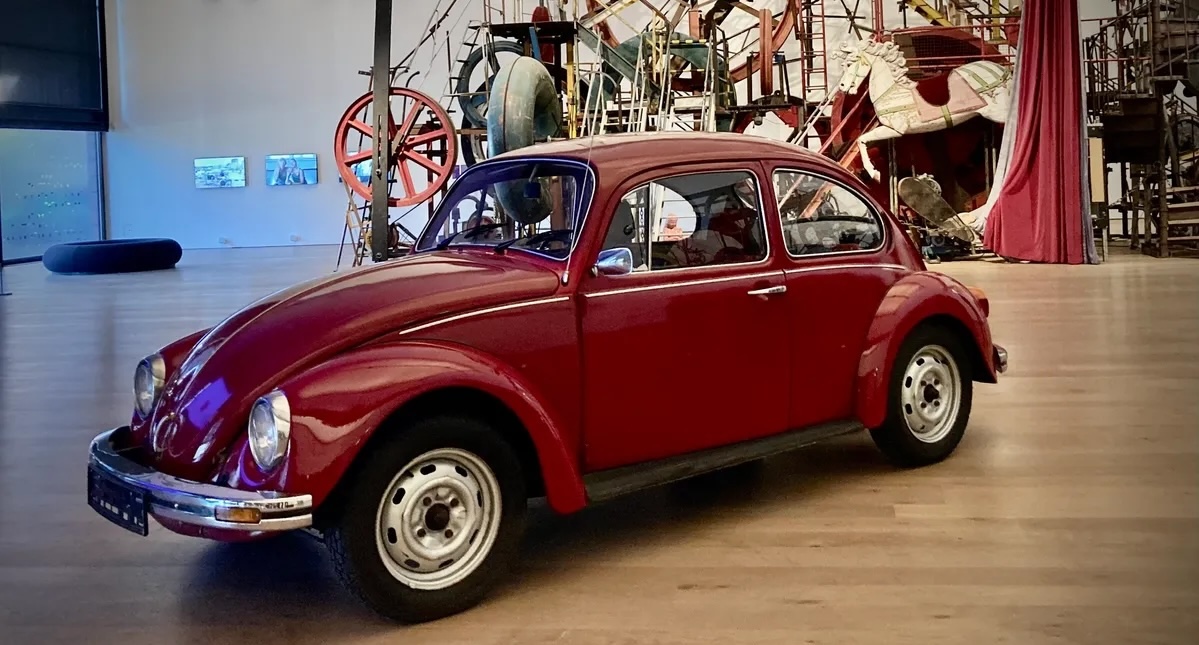 Roter VW Käfer vor einer Tinguely-Installation im Museum