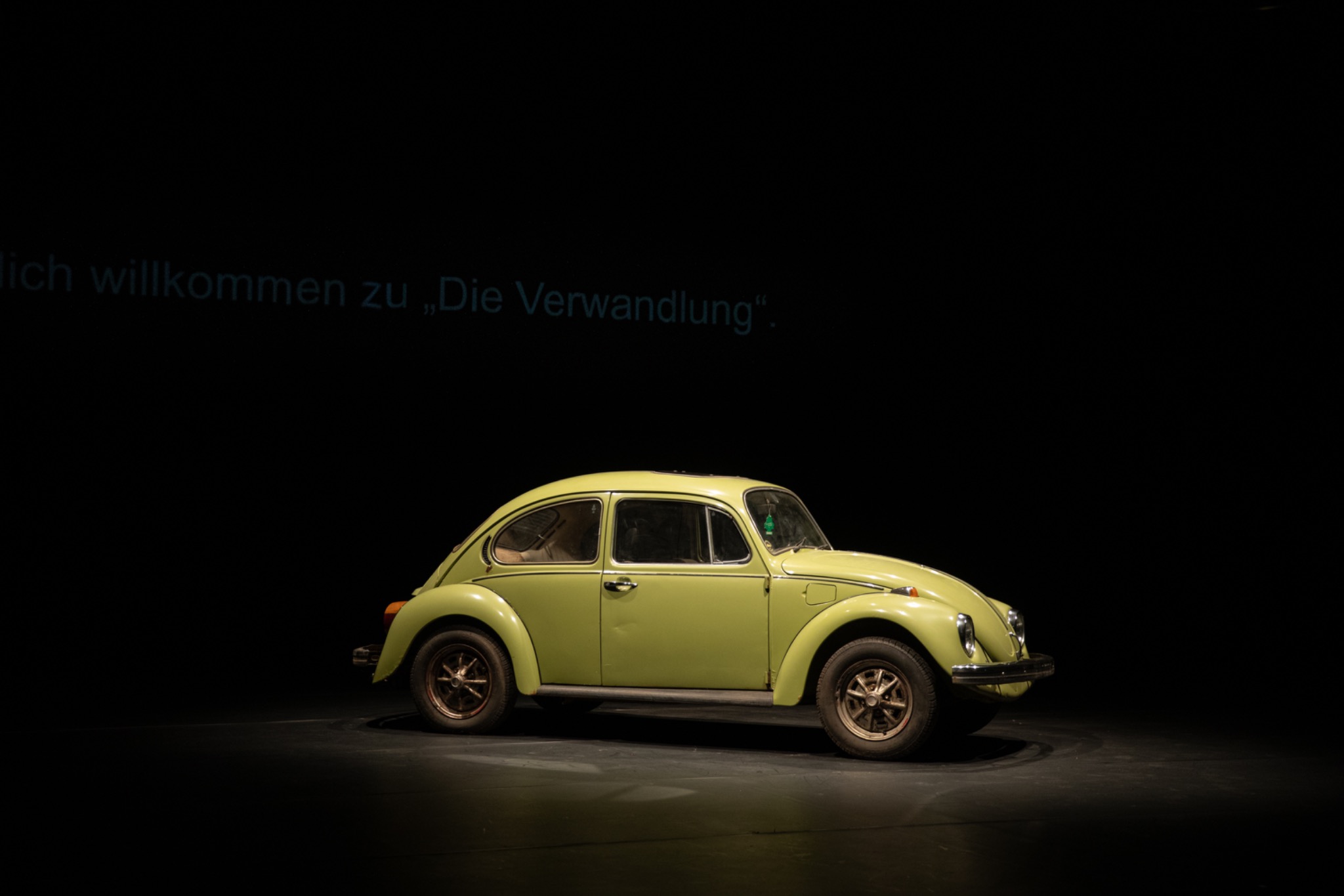 Grüner VW Käfer auf der dunklen Bühne von Die Verwandlung