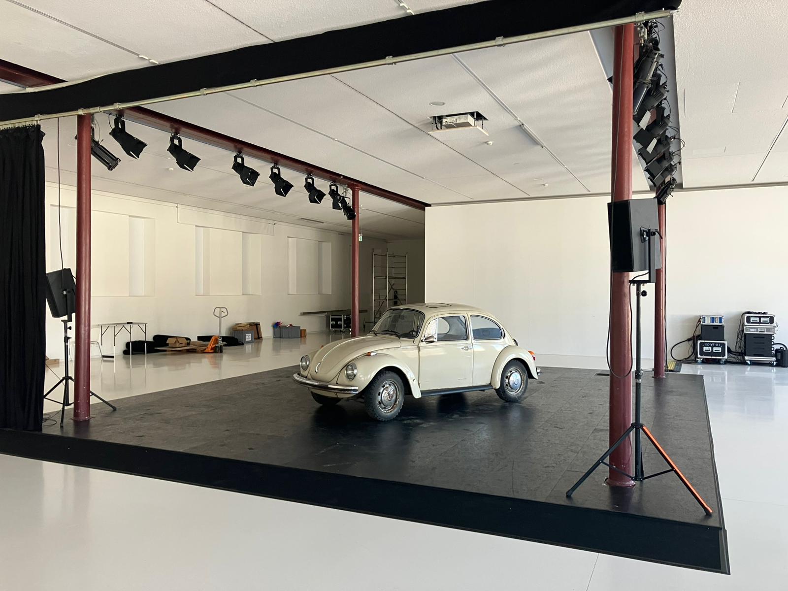 Beiger VW Käfer in einem hellen Ausstellungsraum